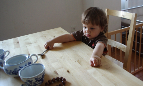 Matěj sed&iacute; u stolu na norm&aacute;ln&iacute; židli