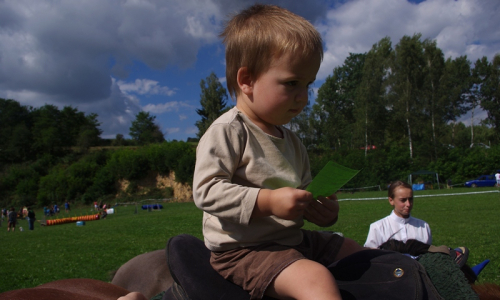 Matěj sed&iacute; poprv&eacute; v sedle koně.