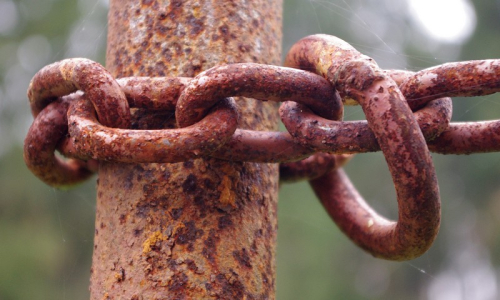 Rezav&yacute; sloup a řetěz v podzimn&iacute;m světle.