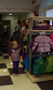 Mal&aacute; modelka předv&aacute;d&iacute; dětskou bundu.