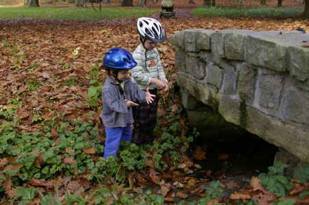 Kluci sesedli z koloběžky a odr&aacute;žedla, aby si pohr&aacute;li s potůčkem.