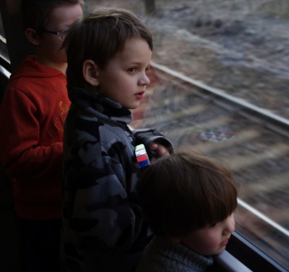 Jedeme vlakem, kluci u okna.